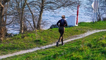 A woman jogs with a helmet on her ears on March 8, 2025 in Guilherand-Granges (Ardèche). (Nicolas Guyonnet / Hans Lucas)