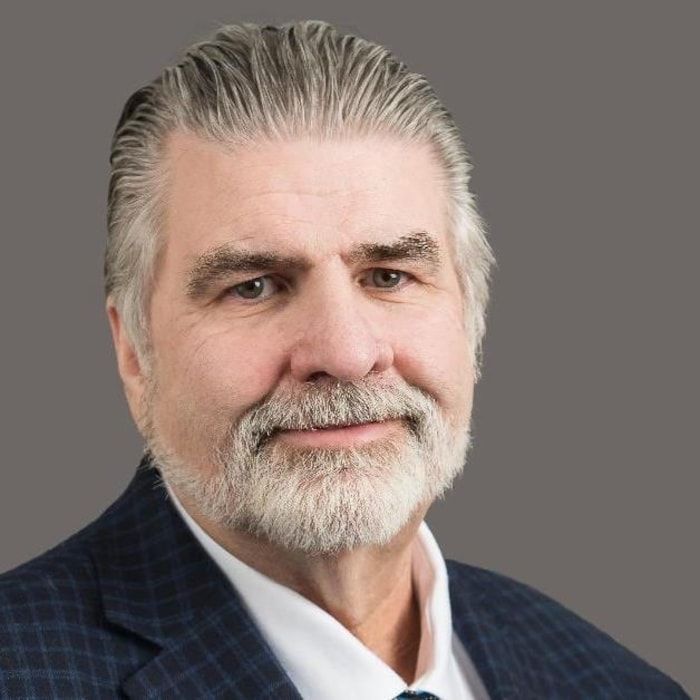 Professional portrait of a man with a graying beard and well -shaped hair.