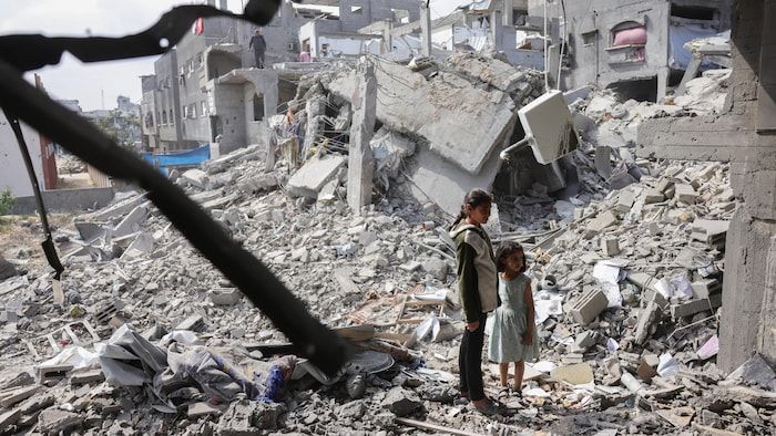 Palestinian girls look at a house destroyed by Israeli strikes in Beit Lahya, in the north of the Gaza Strip, April 28, 2025.