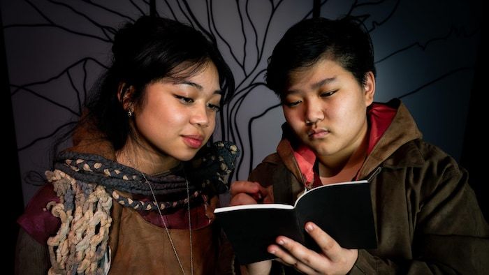 Two teenagers who read a notebook.