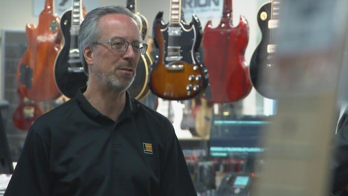 Yvan Moreau in an interview in front of guitars.