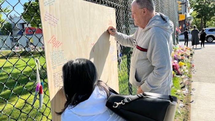 People write on a sign.
