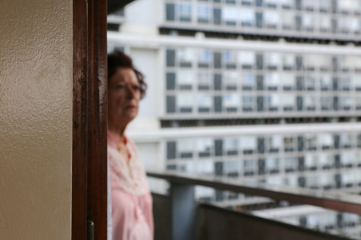 A blurred woman standing on a balcony with a large facade of building in the background. A blurred woman standing on a balcony with a large facade of building in the background.