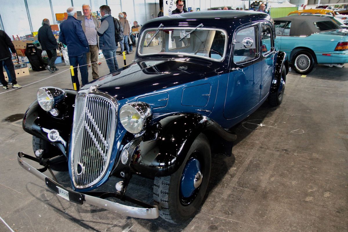 Old blue and black car exhibited during a car show, surrounded by visitors. Old blue and black car exhibited during a car show, surrounded by visitors.