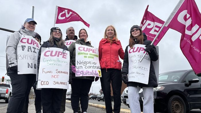 Six employees on strike from the Canadian Hearing Services in Sudbury and the deputy France Gélinas standing in front of the camera.
