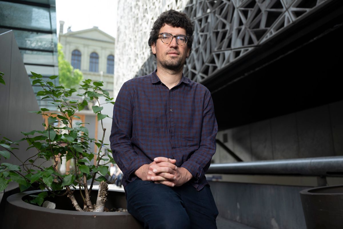 Hadrien Buclin, general deputy on the left, seated in Lausanne, on May 02, 2025, seeking to file a request for a parliamentary commission of inquiry on the tax shield. In the background, a modern building. © Florian Cella / Tamedia Hadrien Buclin, general deputy on the left, seated in Lausanne, on May 02, 2025, seeking to file a request for a parliamentary commission of inquiry on the tax shield. In the background, a modern building. © Florian Cella / Tamedia