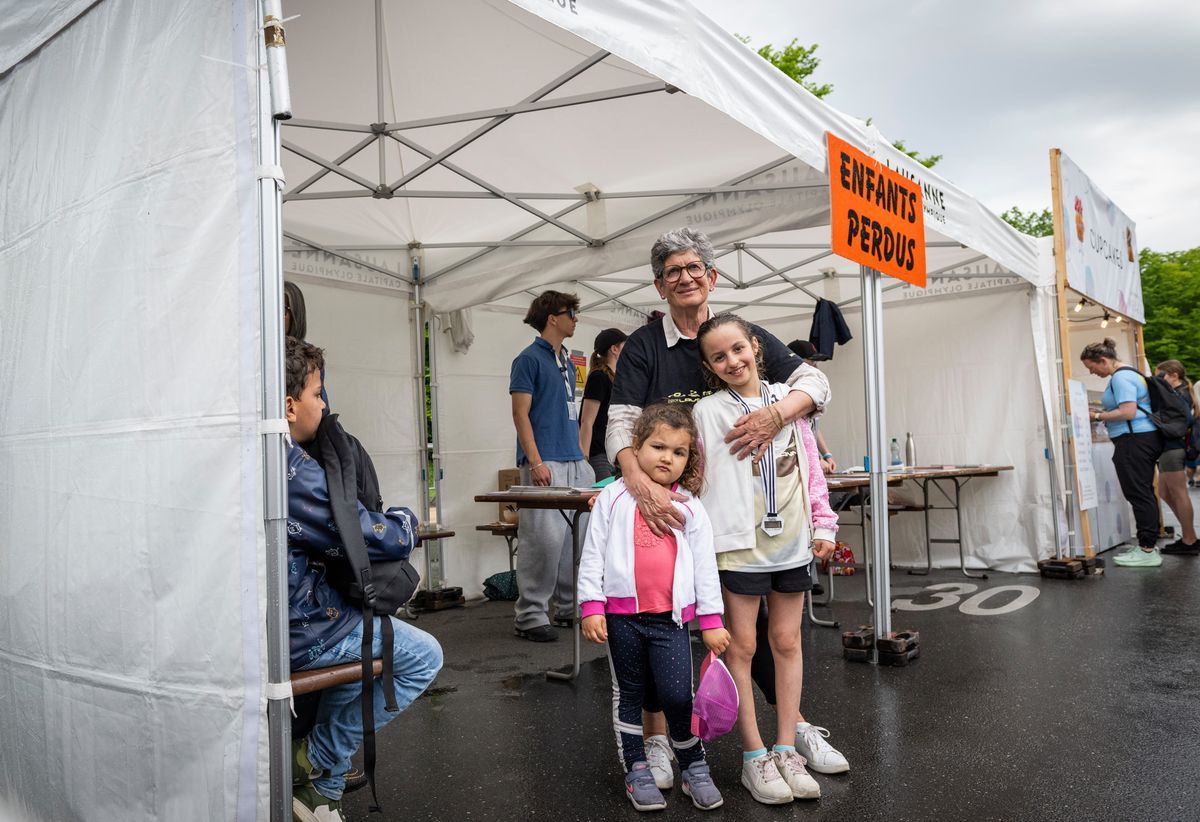 A stand of children lost 20 km from Lausanne, with a volunteer and two smiling children in front of the tent. Photo Jean-Guy Python. A stand of children lost 20 km from Lausanne, with a volunteer and two smiling children in front of the tent. Photo Jean-Guy Python.