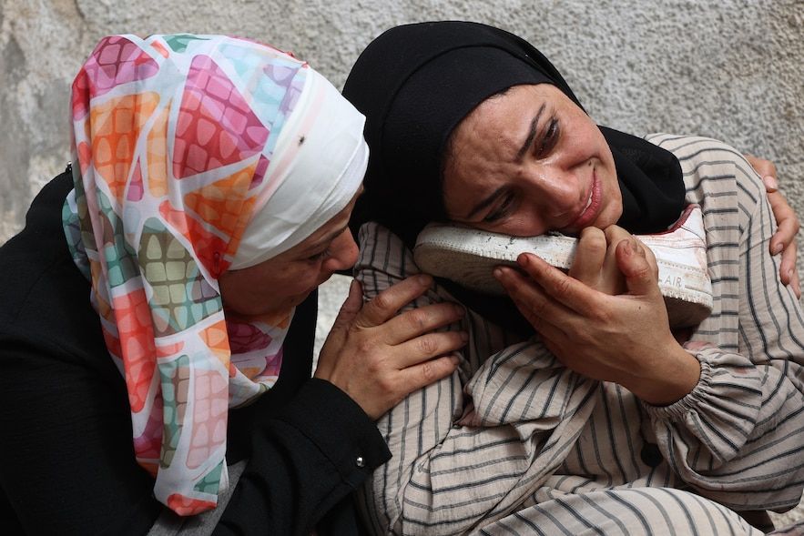 A Palestinian woman cries while holding the bloody shoe of a loved one killed during an Israeli strike, at the Al-Chifa hospital, in Gaza-Ville, in the center of the Gaza Strip, April 28, 2025
