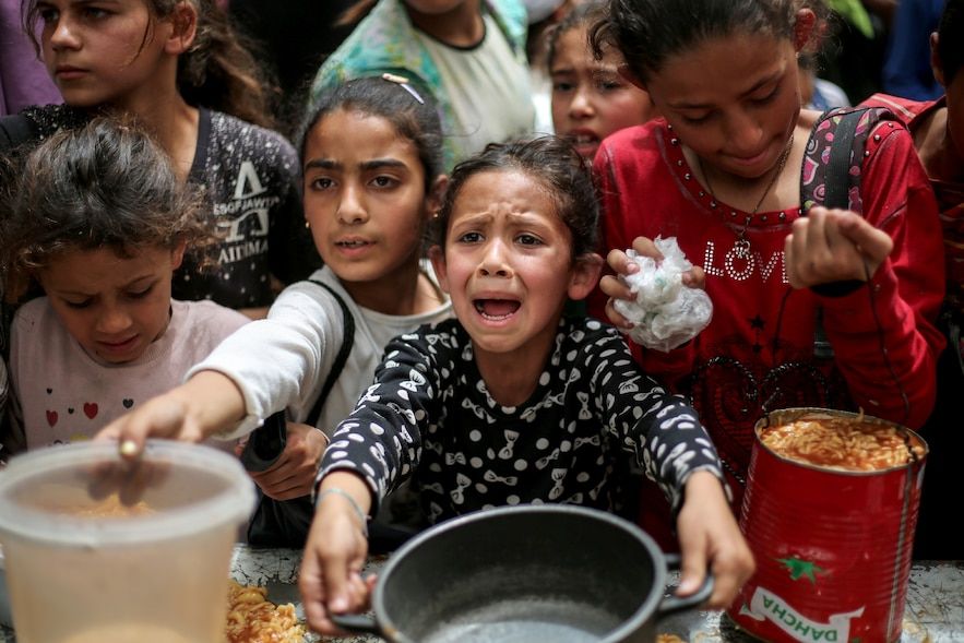 Palestinian children are waiting to receive a hot meal in a charity in Gaza-Ville, April 30, 2025