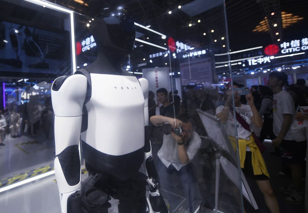 Tesla Bot Optimus exhibited at the World Conference IA 2024 at the Shanghai exhibition center, with visitors taking photos. Tesla Bot Optimus exhibited at the World Conference IA 2024 at the Shanghai exhibition center, with visitors taking photos.