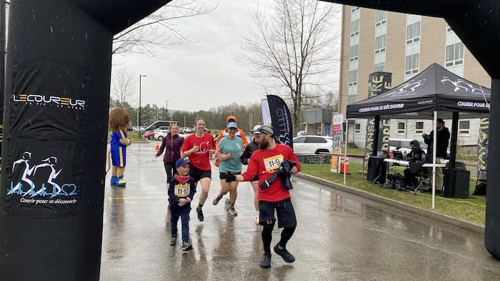 A team of runners crosses the finish line.