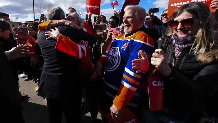 Mark Carney tightens supporters in his arms.