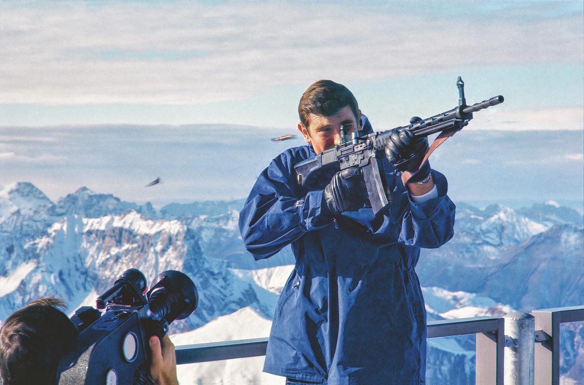 George Lazenby as James Bond on the Gloria Piz, holding a rifle during a shoot, with the Swiss Alps in the background. George Lazenby as James Bond on the Gloria Piz, holding a rifle during a shoot, with the Swiss Alps in the background.