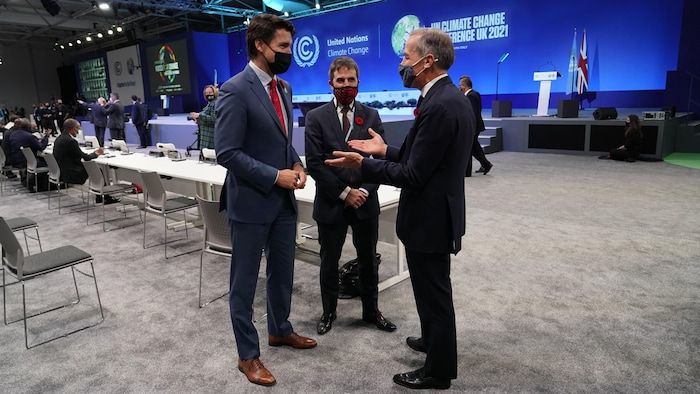 The three men discuss.