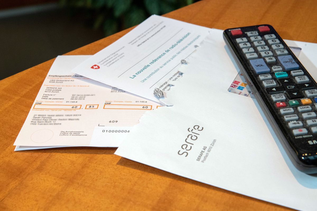 Invoices Serafe, Lausanne, 2019, with errors, placed on a table next to a remote control. Invoices Serafe, Lausanne, 2019, with errors, placed on a table next to a remote control.