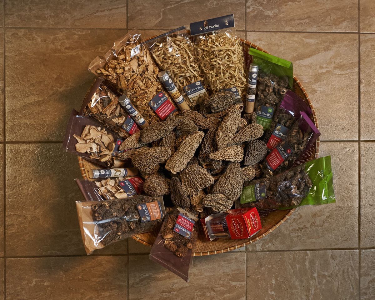 Basket furnished with various dried and wrapped mushrooms, arranged on tiled floor. Basket furnished with various dried and wrapped mushrooms, arranged on tiled floor.