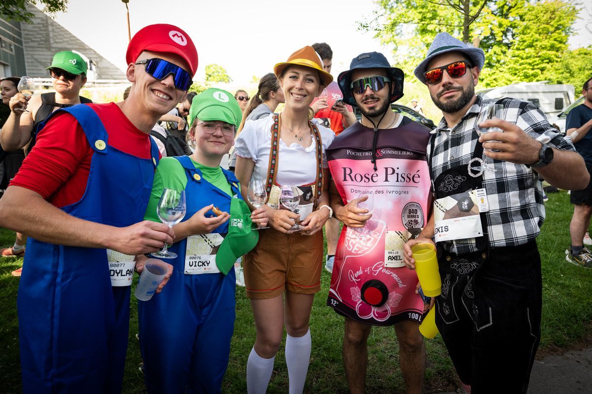Participants disguised at the 20 km of Lausanne, including in video game characters and wine bottles, holding glasses during the aperitif run. Photo by Jean-Guy Python. Participants disguised at the 20 km of Lausanne, including in video game characters and wine bottles, holding glasses during the aperitif run. Photo by Jean-Guy Python.